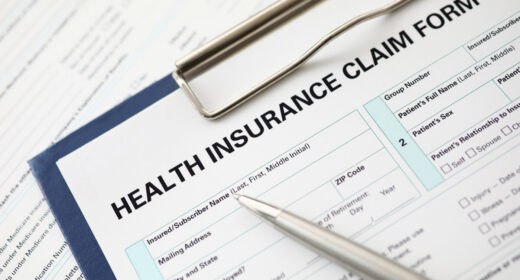 A pen sits on an insurance form on a clipboard.